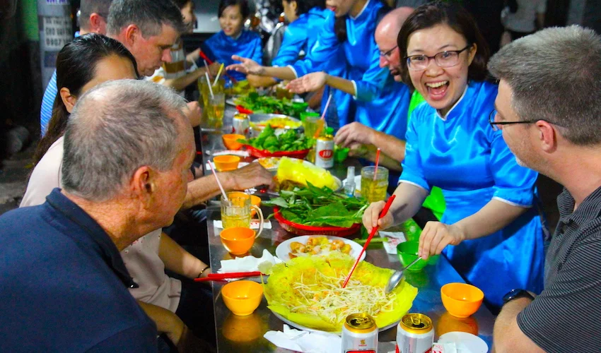 female tour guides team serving Banh Xeo